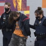 police lead handcuffed suspect down Wall Street